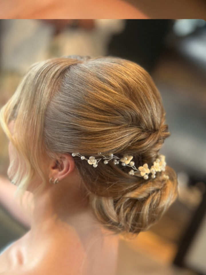 Low bridal chignon with a flower vine, photographed from behind